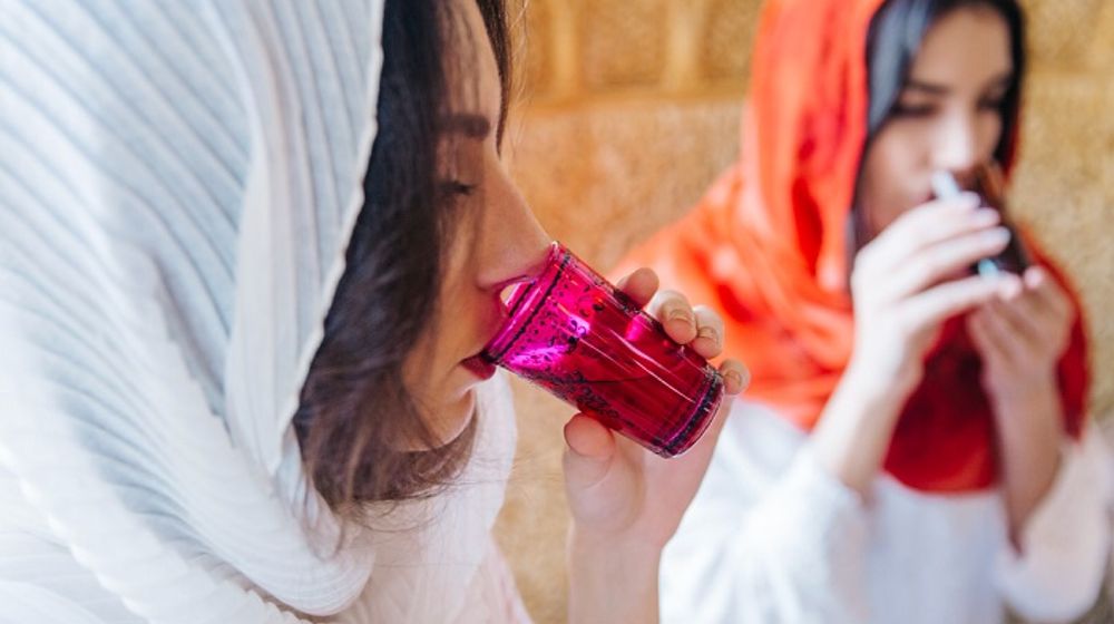 Ilustrasi wanita muslim sedang minum.