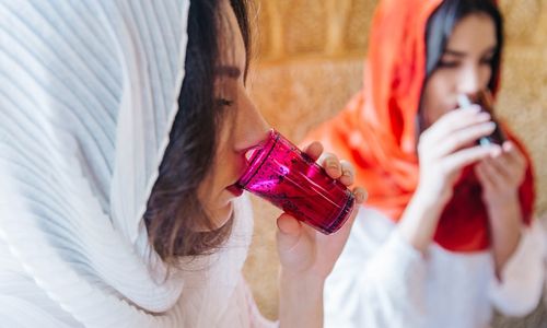 Ilustrasi wanita muslim sedang minum.