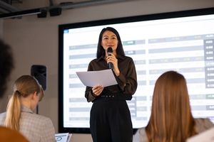 Ilustrasi wanita sedang berbicara di depan umum.