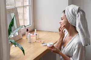 Ilustrasi wanita sedang menggunakan produk kecantikan.