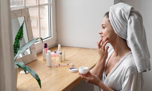 Ilustrasi wanita sedang menggunakan produk kecantikan.