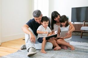 happy-parents-cute-kids-using-mobile-devices-floor-living-room_74855-8108.jpg