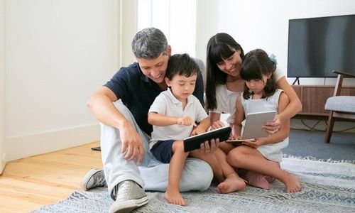 happy-parents-cute-kids-using-mobile-devices-floor-living-room_74855-8108.jpg