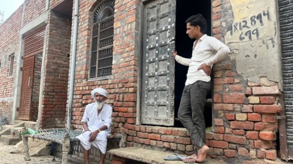 Seorang warga lanjut usia di Uttawar, yang hidup pada masa darurat, duduk di luar rumahnya.