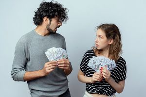 Ilustrasi pasangan sedang memegang uang.