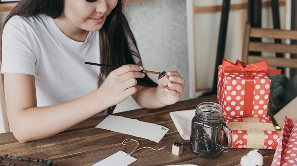 Ilustrasi wanita sedang membuat kerajinan tangan.