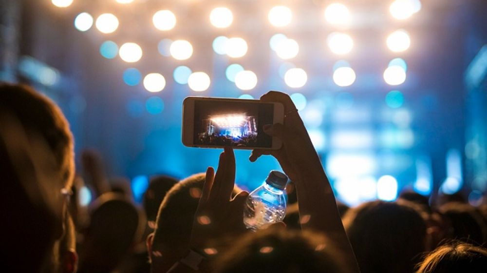 Ilustrasi orang berada di kerumunan sedang menonton konser musik.
