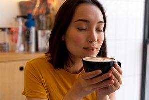 Ilustrasi wanita sedang minum kopi.