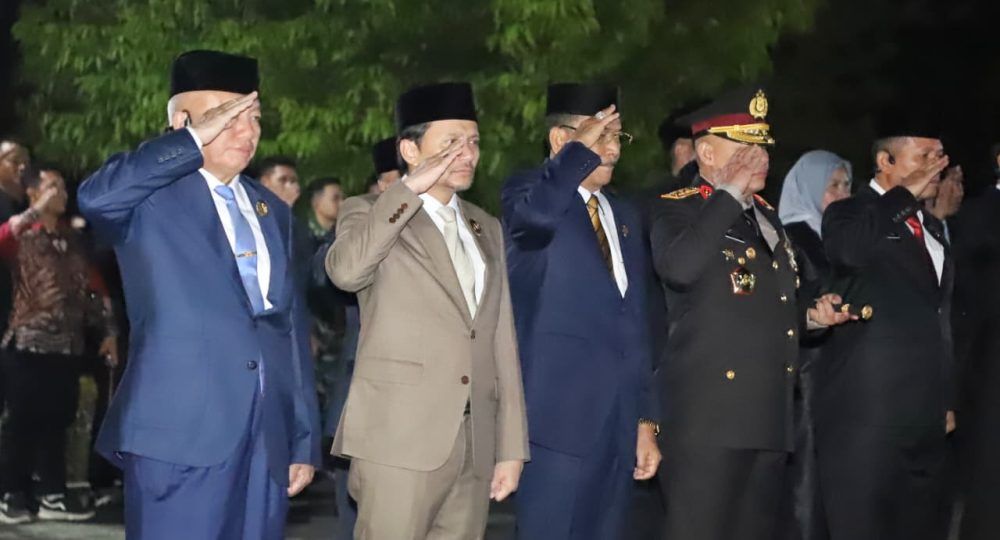 Tepat tengah malam di Taman Makam Pahlawan Bumi Kencana, Landasan Ulin, Banjarbaru, suasana berubah hening. Lampu-lampu dipadamkan, dua prajurit TNI melangkah membawa obor, menyalakan cahaya yang berpendar di tengah udara dingin dini hari, Minggu (17/8/2025)