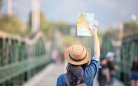 Ilustrasi seorang wisatawan membawa travel map.