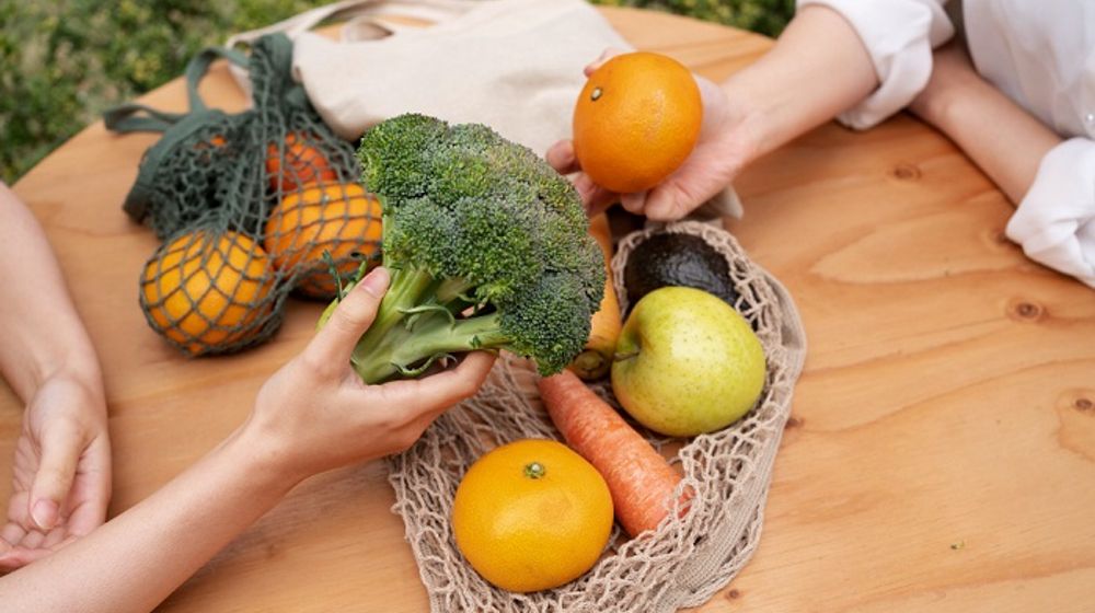 Ilustrasi wanita sedang membawa sayur dan buah, makan sehat berkelanjutan.