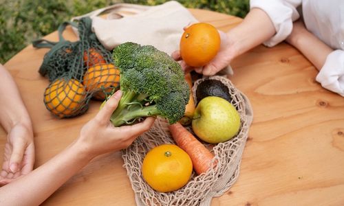 Ilustrasi wanita sedang membawa sayur dan buah, makan sehat berkelanjutan.
