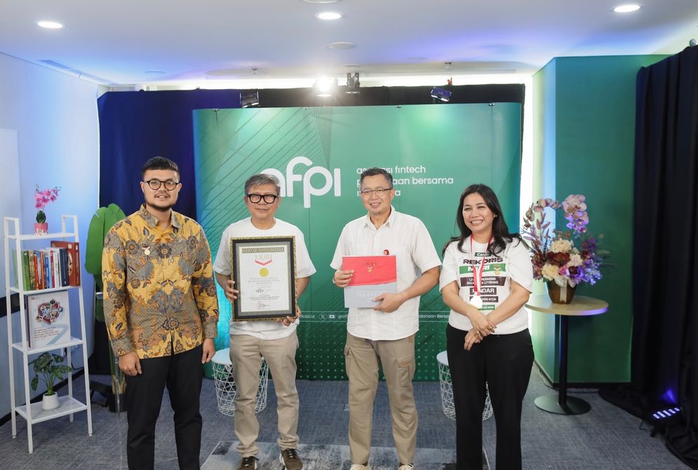 Ketua Umum Asosiasi Fintech Pendanaan Bersama Indonesia (AFPI) Entjik S. Djafar (kedua dari kiri), Direktur Eksekutif AFPI Yasmine Meylia Sembiring (pertama dari kanan), dan Kepala Departemen Perizinan, Pemeriksaan Khusus dan Pengendalian Kualitas Pengawasan PVML OJK, Edi Setijawan (kedua dari kanan) menerima piagam penghargaan dari Customer Relations Manager Museum Rekor Indonesia (MURI), Lutvi Syah Pradana (pertama dari kiri) atas rekor Siaran Langsung Edukasi Literasi Pinjaman Daring (Pindar) secara Nonstop Terlama melalui YouTube.