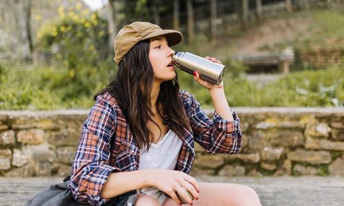 Wanita menggunakan botol minum sendiri guna mengurangi sampah plastik.