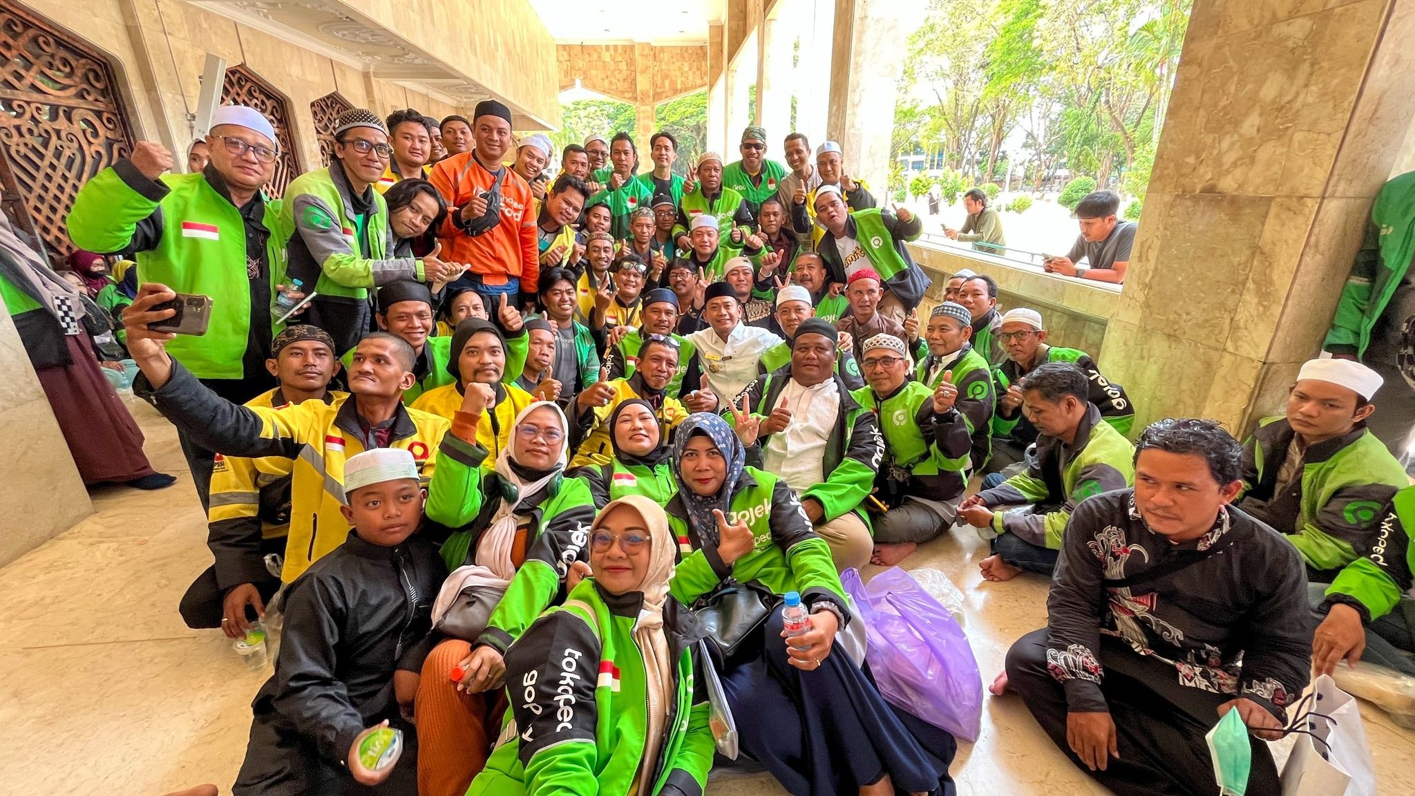 Para driver ojol berfoto di teras Masjid Raya Sabilal Muhtadin.