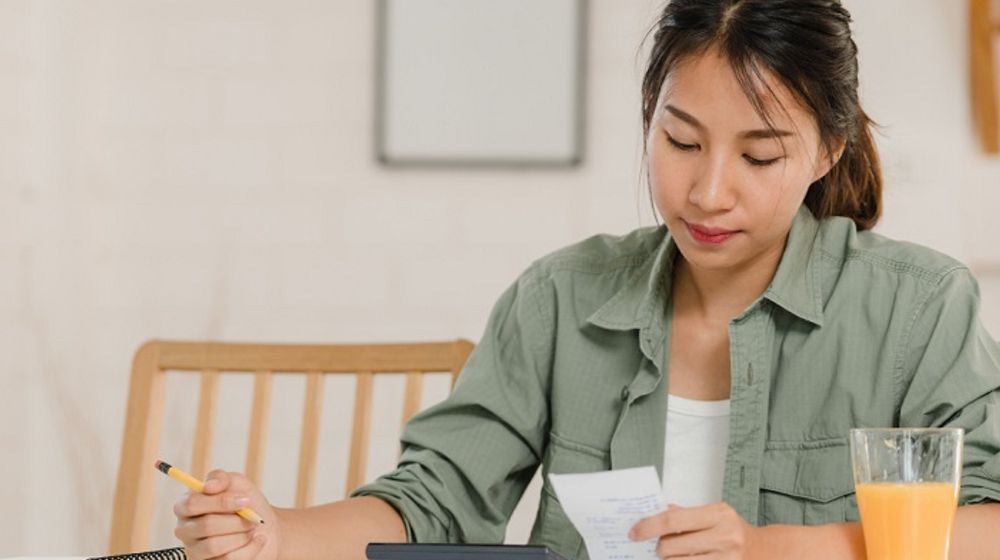 Ilustrasi wanita sedang membuat anggaran keuangan pribadi.