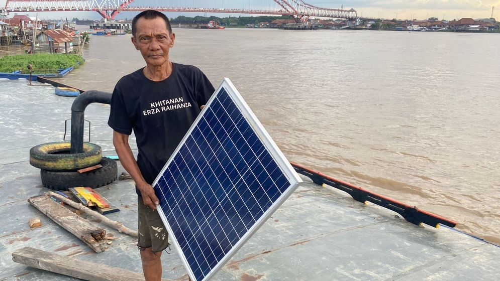 Abadi salah seorang sopir perahu di perairan Sungai  Musi menunjukan panel surya yang digunakannya  untuk mendukung aktivitasnya