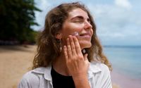 Ilustrasi wanita menggunakan sunscreen.