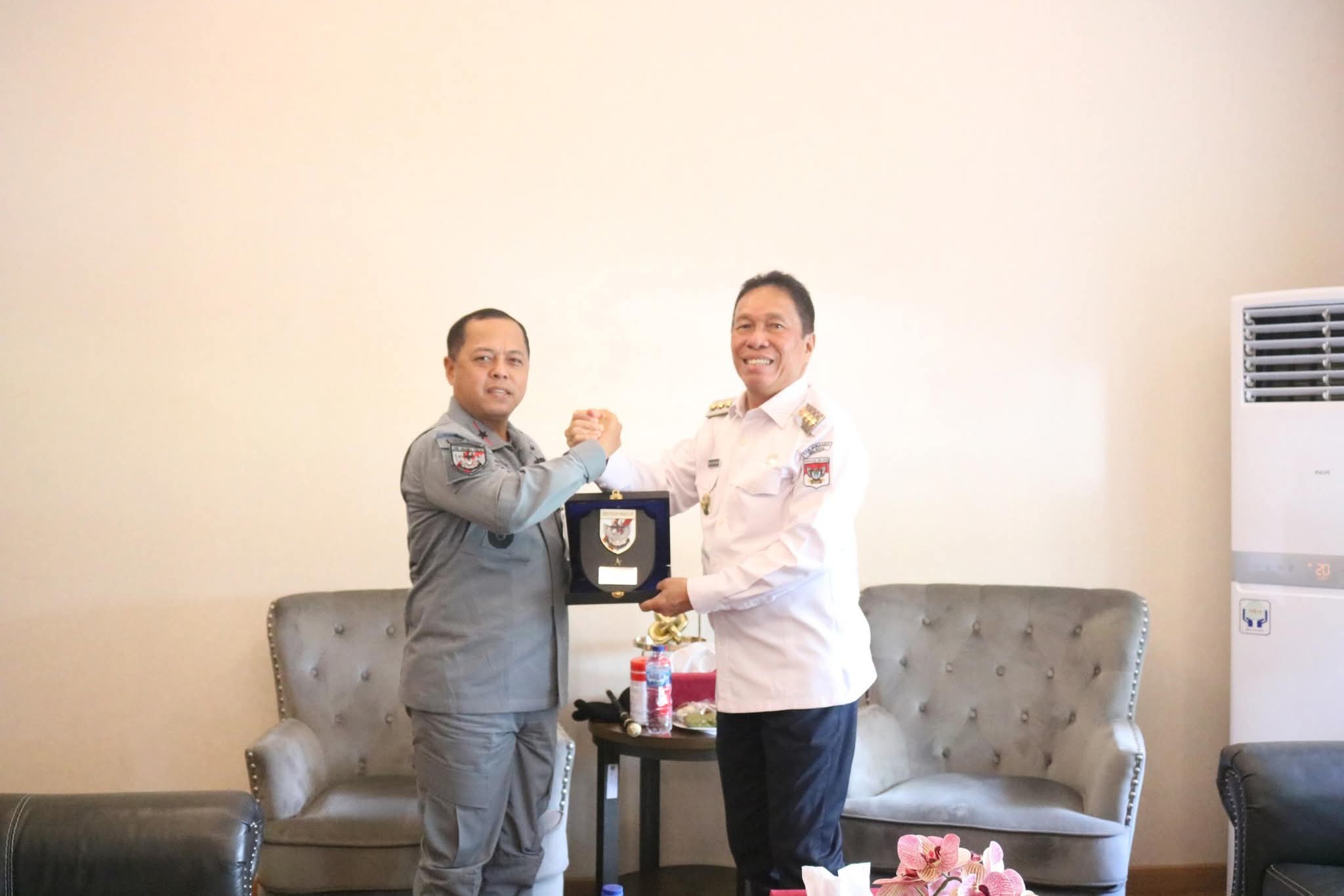 Bupati Minahasa Selatan, Franky Wongkar dan Kepala Zona Tengah Badan Keamanan Laut (Bakamlah) Republik Indonesia Teguh Prasetya bertukar cenderamata usai pertemuan.