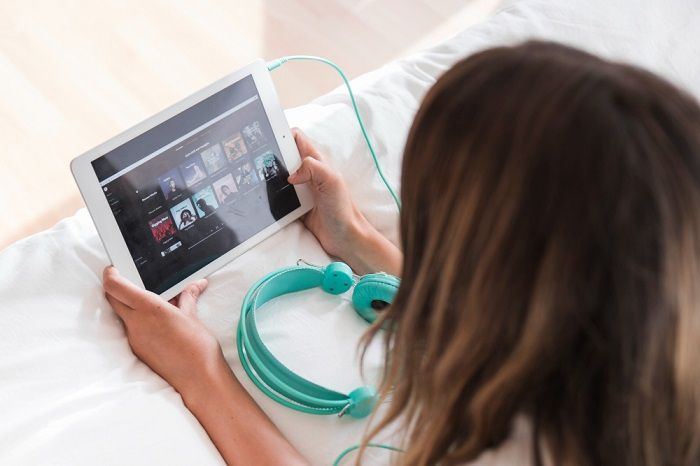 Ilustrasi wanita sedang streaming musik.