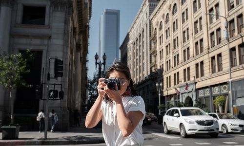 Ilustrasi orang sedang memotret di jalan.