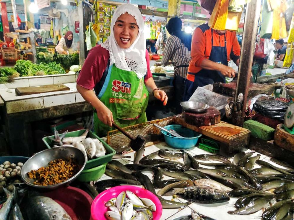 Seorang pedagang sedang melayani pembeli di Pasar Padang Selasa Palembang, Kamis (6/11/2025)