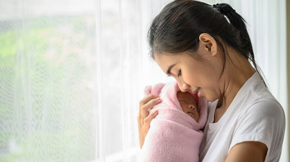 Ibu menggendong bayi yang baru lahir.