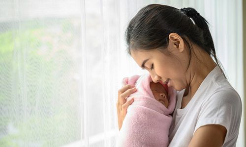 Ibu menggendong bayi yang baru lahir.