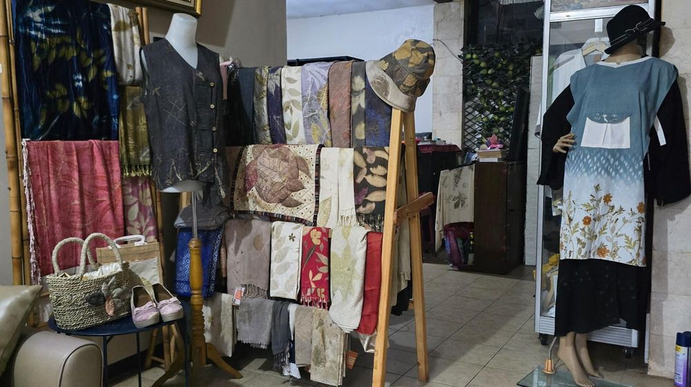 Deretan busana dan aksesori ecoprint dengan motif daun dan pewarna alami karya Qaniacraft Ecoprint dipajang di ruang produksi.