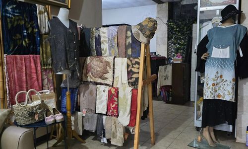 Deretan busana dan aksesori ecoprint dengan motif daun dan pewarna alami karya Qaniacraft Ecoprint dipajang di ruang produksi.