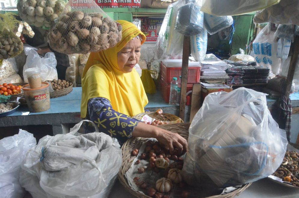 Sophia (55), salah satu pedagang yang telah berjualan sejak 1995 di Pasar Cinde menyusun barang dagangannya