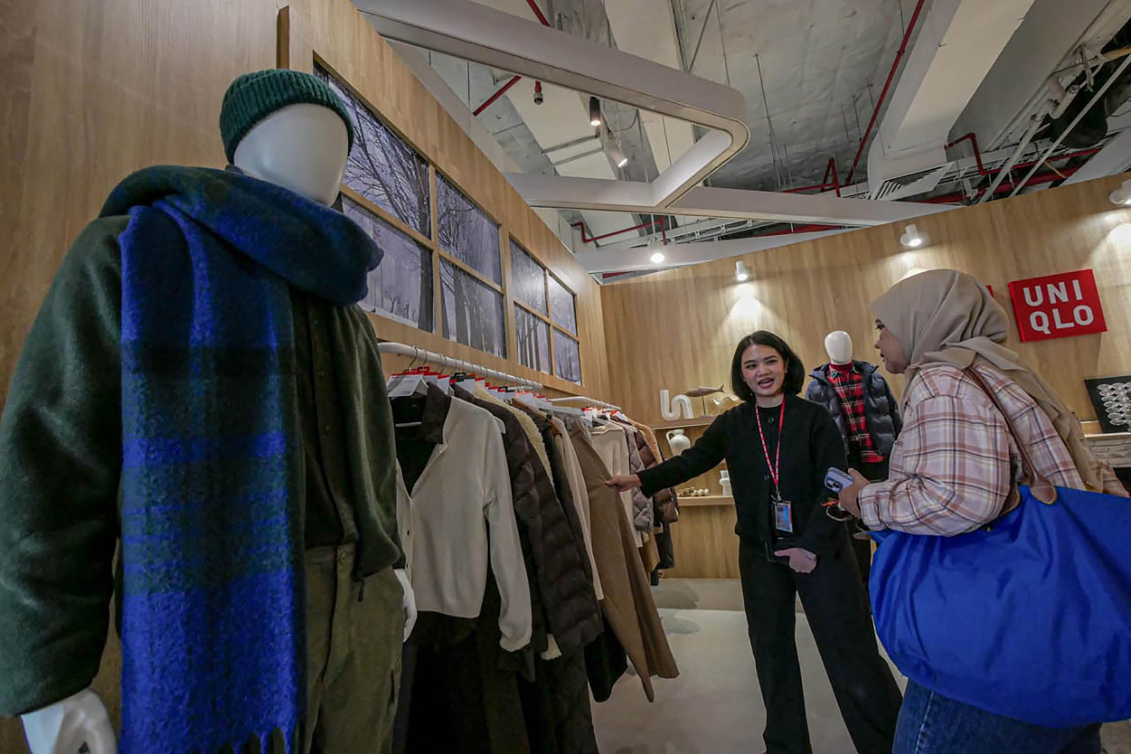 Nampak pengunjung tengah mengamati koleksi fashion yang ada disalah satu gerai Uniqlo di pusat pebelanjaan. Foto : Panji Asmoro/TrenAsia