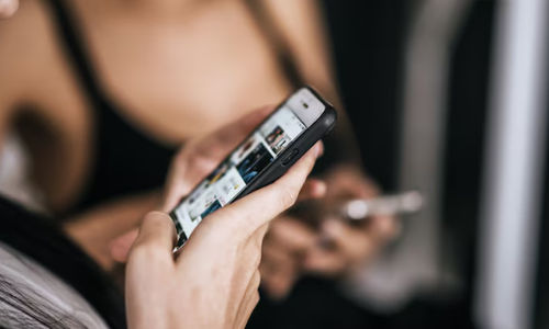 Ilustrasi seseorang menggenggam ponsel terlalu lama.