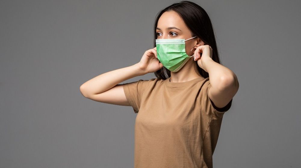 Perempuan menggunakan masker untuk mencegah virus super flu.