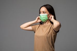 Perempuan menggunakan masker untuk mencegah virus super flu.