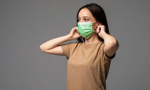 Perempuan menggunakan masker untuk mencegah virus super flu.