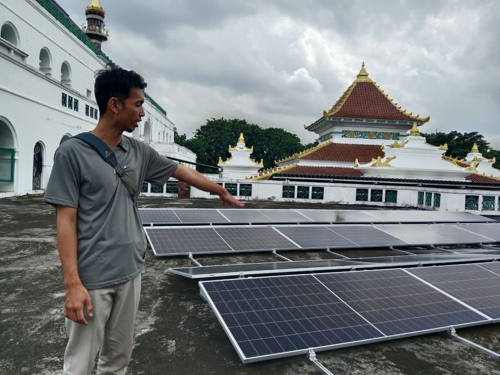 Petugas teknis PLTS Masjid Agung menunjukan panel surya yang terpasang di atap masjid