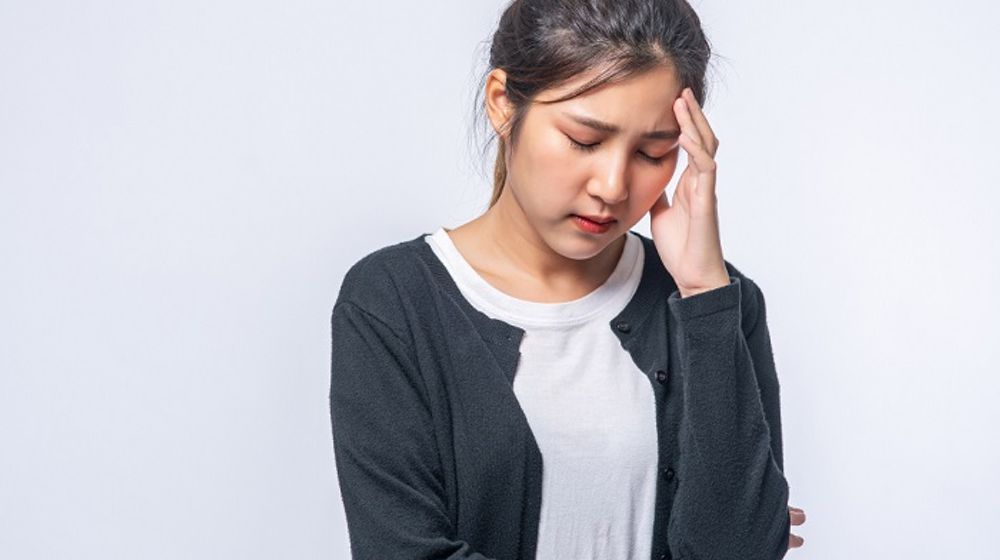 Seorang wanita tengah sakit kepala atau vertigo.