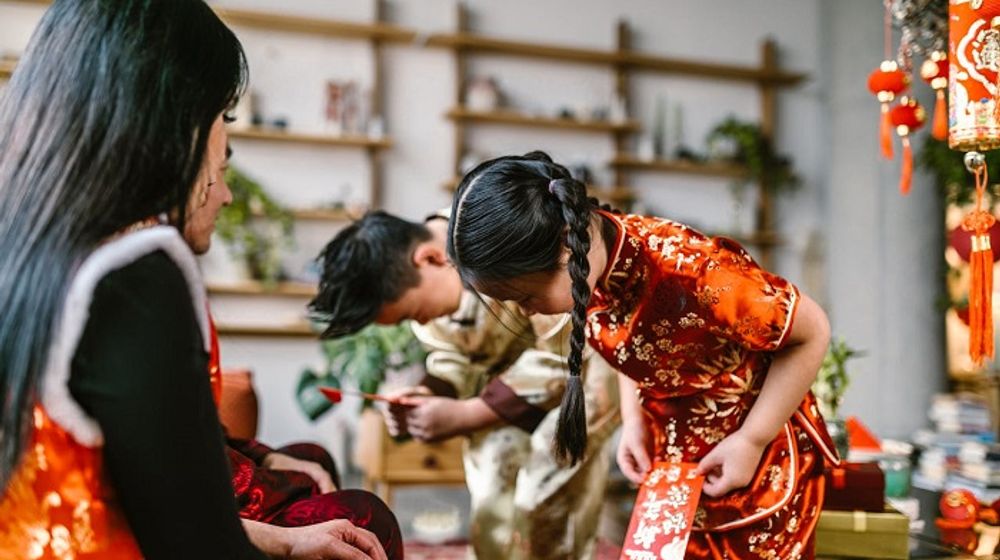 Anak-anak menerima angpau saat Tahun Baru Imlek.