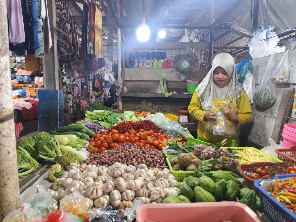 seorang pedagang bahan pangan di Pasar Sekip Ujung Palembang menyusun dagangannya