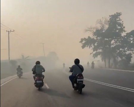 Asap tebal menyelimuti kota Landasan Ulin, Kalimantan Selatan,Minggu (22/8/2026). Dampak karhutla di Kalteng meluas