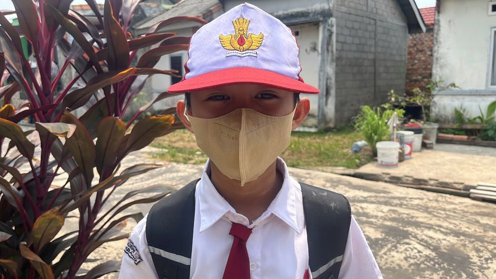 Seorang siswa sekolah dasar di Palembang terpaksa menggunakan masker untuk menghindari dampak buruk kabut asap