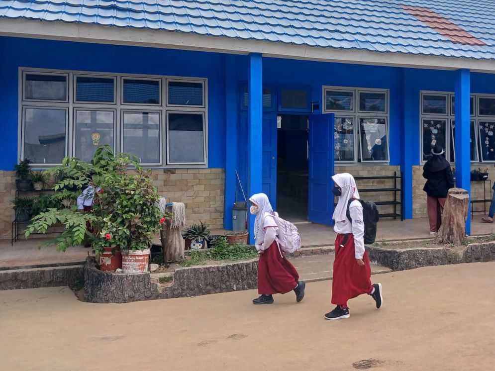 Sejumlah siswa berjalan menuju kelasnya, pada hari perdana masuk sekolah setelah dua pekan sekolah pembelajaran jarak jauh